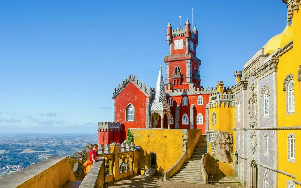 La tour de l'horloge rouge et la façade jaune du palais de Pena