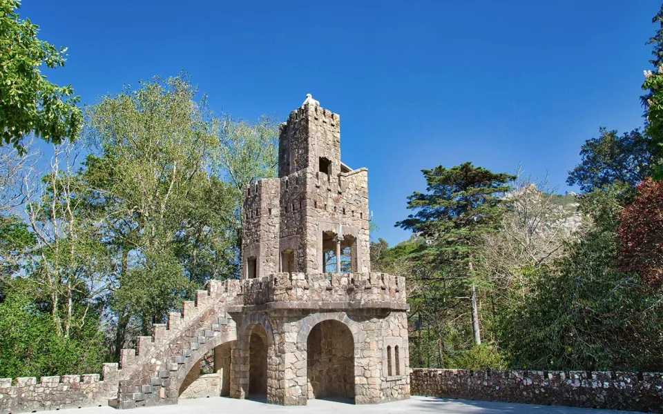 Una torre de piedra entre los jardines de la finca