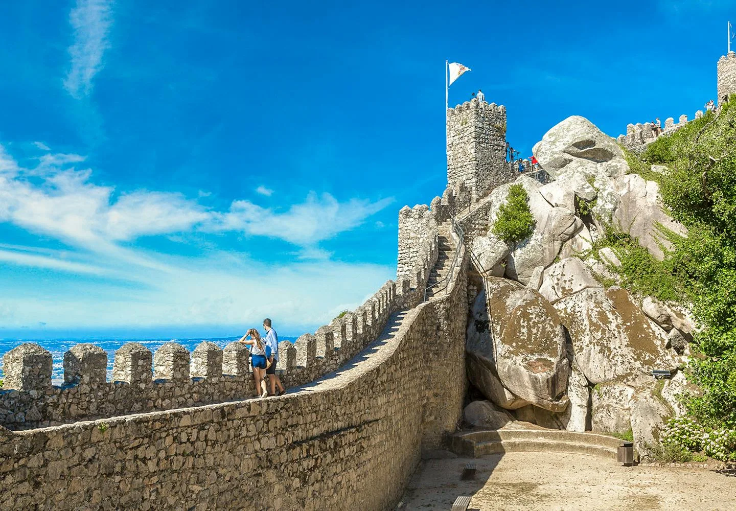 Visitors walking the stone ramparts of the Moorish Castle